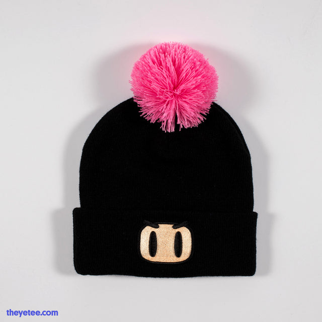 Black winter knit hat has embroidered Bomberman face. Hot pink pom pom on top - Bomberman Winter Cap