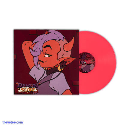 Side profile of a red horned demon girl with purple hair and shaved sides. Matching purple shirt and demon skull earbuds. 