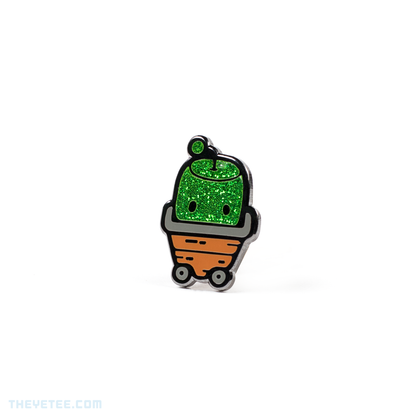 Hard enamel pin of a green sparkly Junimo- a forest spirit in Stardew Valley riding in a garden cart