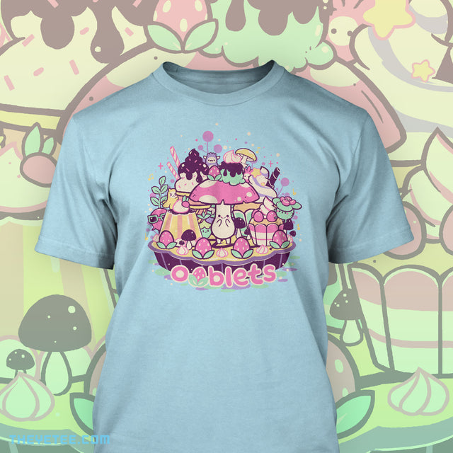 Aqua tee shirt. Shrumbo standing on a tart. Tart is lined with strawberries and filled with sweet treats. Whirlitzer, Petula, ClickyClaws, and Pantsabear hide amongst the treats. - Oobakery